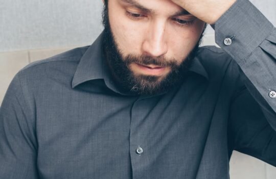 man in black button up shirt holding smartphone